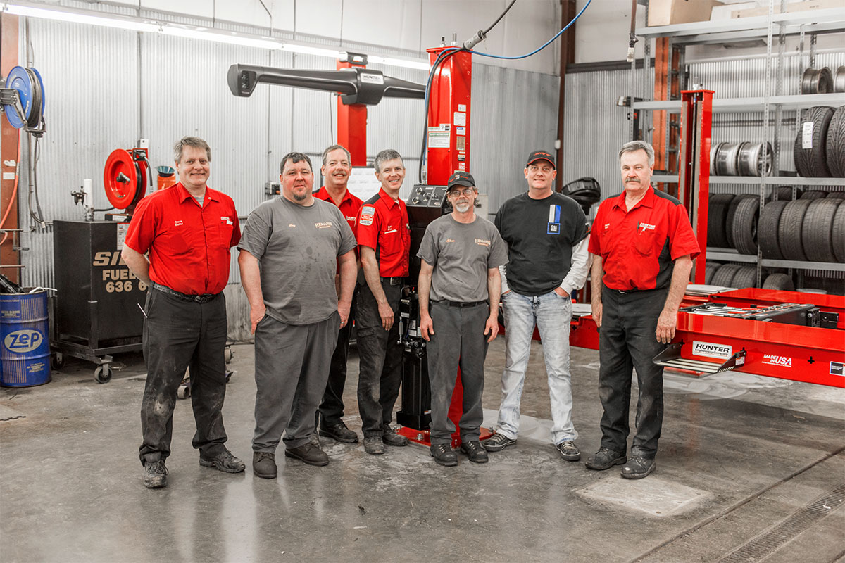 service reps and customer smiling and standing by alignment system